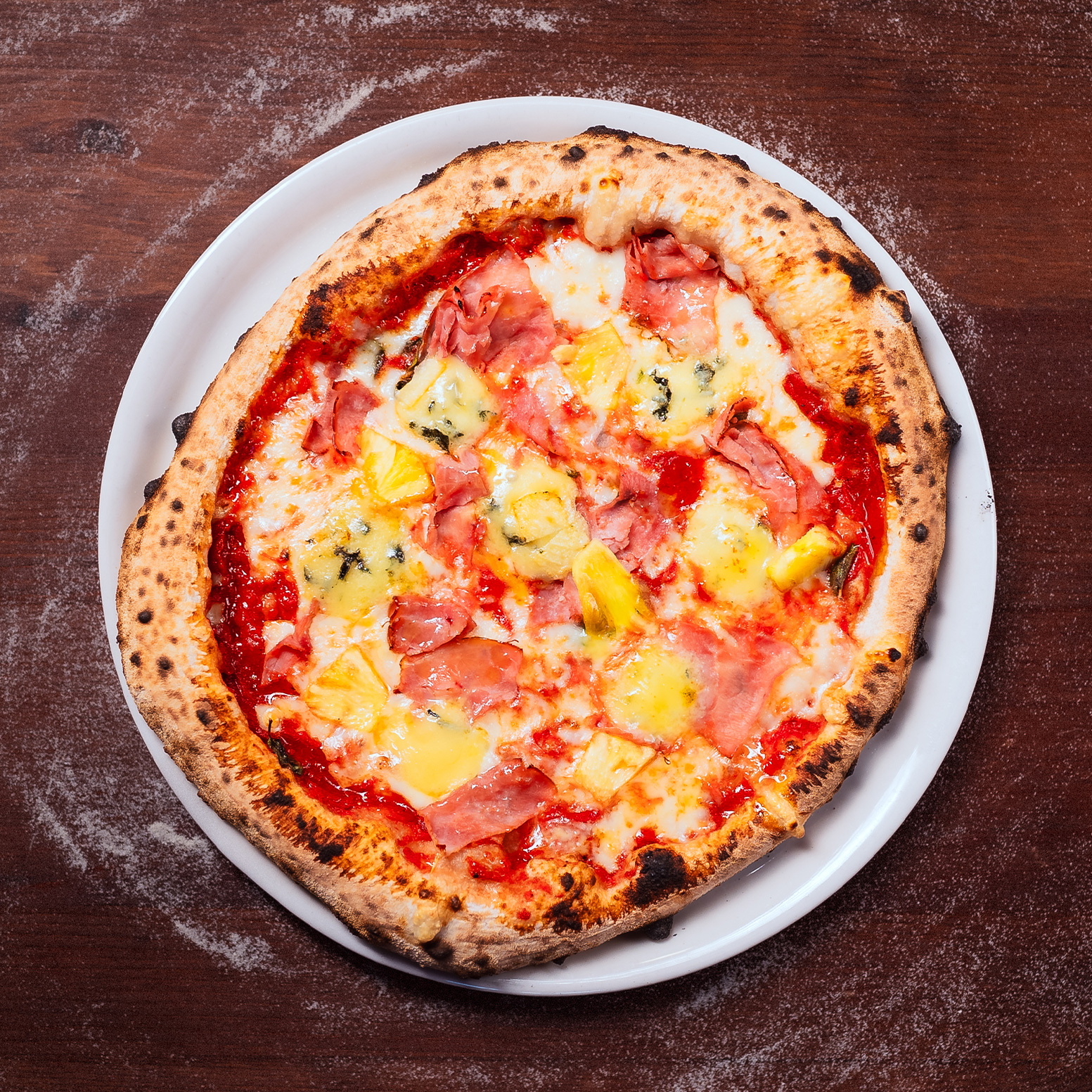 MIKÄ ON MEIDÄN SUOSIKKI? NO ÄITI TIETENKIN! 💖
Jos et tule perjantaina, niin tuo äitisi sunnuntaina pizzalle. 💕
🍍REIPONEN 🐷
Niin uskomatonta kuin se onkin, kinkku-ananas-pizza killuu tälläkin hetkellä suosituimpien pizzojemme listalla! Käytännössä Reiponen on instituutio itsessään ja pizzeriamme kulmakivi. Voinemme todeta, että ananas kuuluu pizzaan!
Reiponen sisältää Tujun tomaattikastiketta, tuoretta oreganoa, Fior di latte -mozzarellaa, Reiposen tilan palvikinkkua, tuoretta ananasta ja Peltolan Blue -juustoa.
Jos äitiä väsyttää, niin Woltti hoitaa lätyt kotiin! No problem!