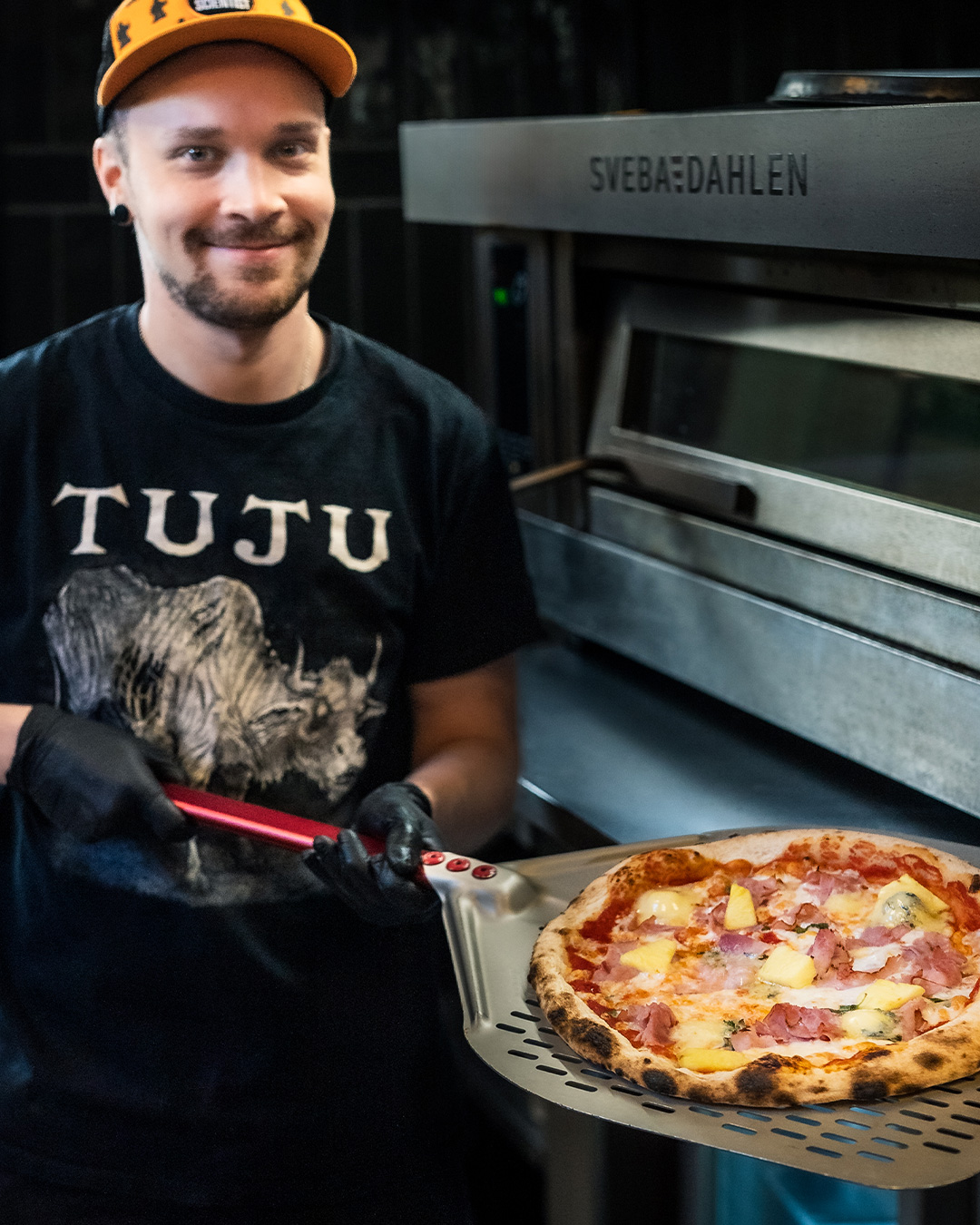 🍍Reiponen-pitsa 🐷

Mariot ja Silviot pyörivät haudoissaan kuin väkkärät, Giorgia suunnittelee jo sotajalalle astumista.  Ei me välitetä. Ei kiinnosta. Meillä on kiire pyörittää lättyjä!

Kaikki tämä  johtuu siitä, että meidän pisimpään listalla ollut pizzamme on myöskin yksi myydyimmistä - ja se on Reiponen! Ananas kuuluu pizzaan.

Leikit sikseen, pizza on mitä mainioin ja sisältää Tujun tomaattikastiketta, tuoretta oreganoa, fior di latte -mozzarellaa, Reiposen tilan palvikinkkua, tuoretta ananasta ja Peltolan blue -juustoa. Kokeile itse ja ylläty!

Jos meille asti kapuaminen on ylitsepääsemätöntä niin Wolt kuskaa lätyt kotia asti!